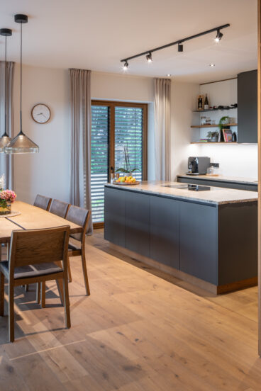 Moderne Küche in Anthrazit und Eichenholz mit eleganter Stein-Arbeitsfläche aus unserer Tischlerei Deutschmann