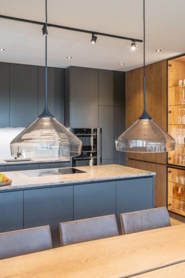 Moderne Küche in Anthrazit und Eichenholz mit eleganter Stein-Arbeitsfläche aus unserer Tischlerei Deutschmann